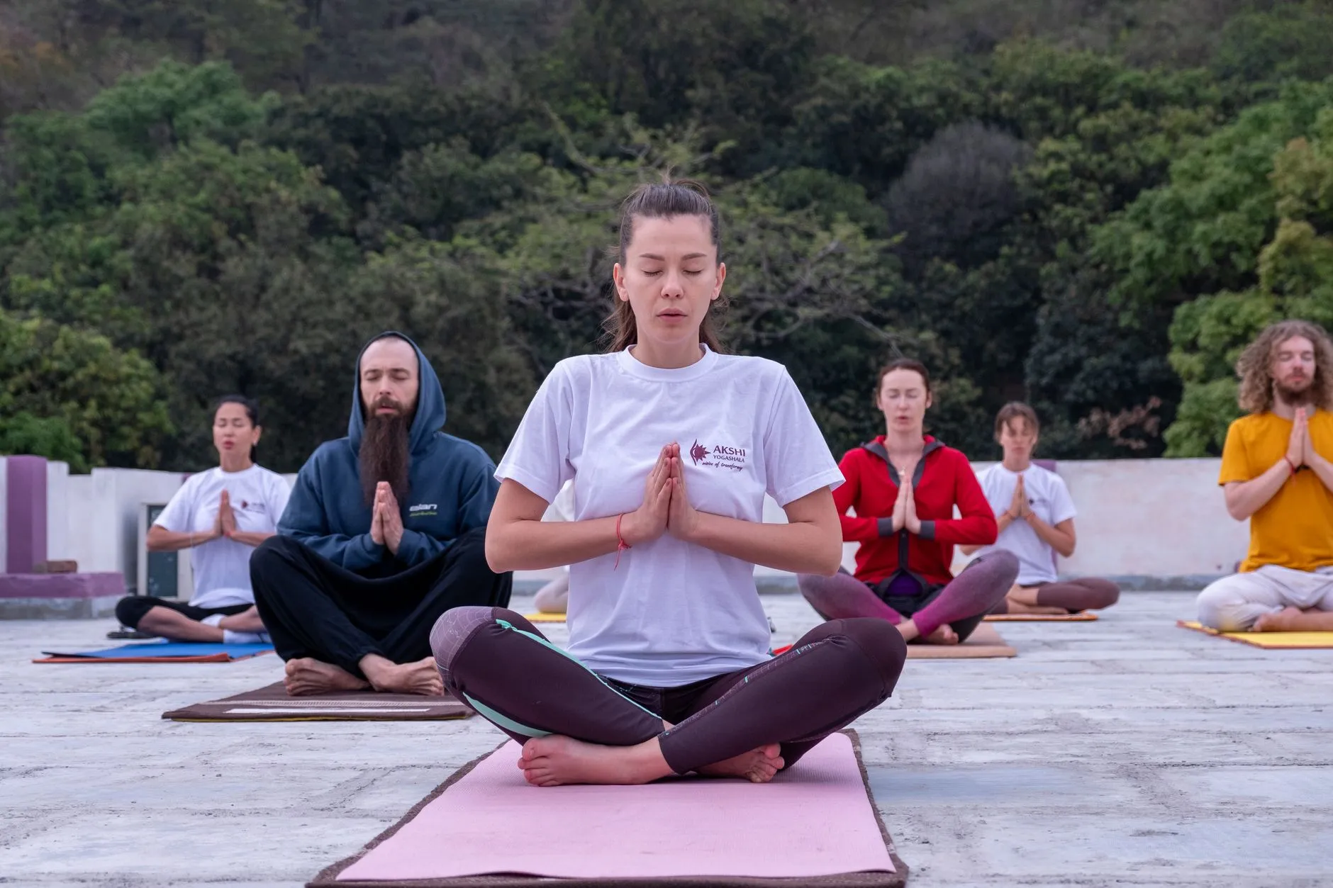 A diverse group practicing yoga during a retreat in Bali.
