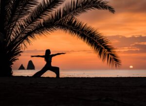 Naukasana being practiced on a beach at sunset in Bali