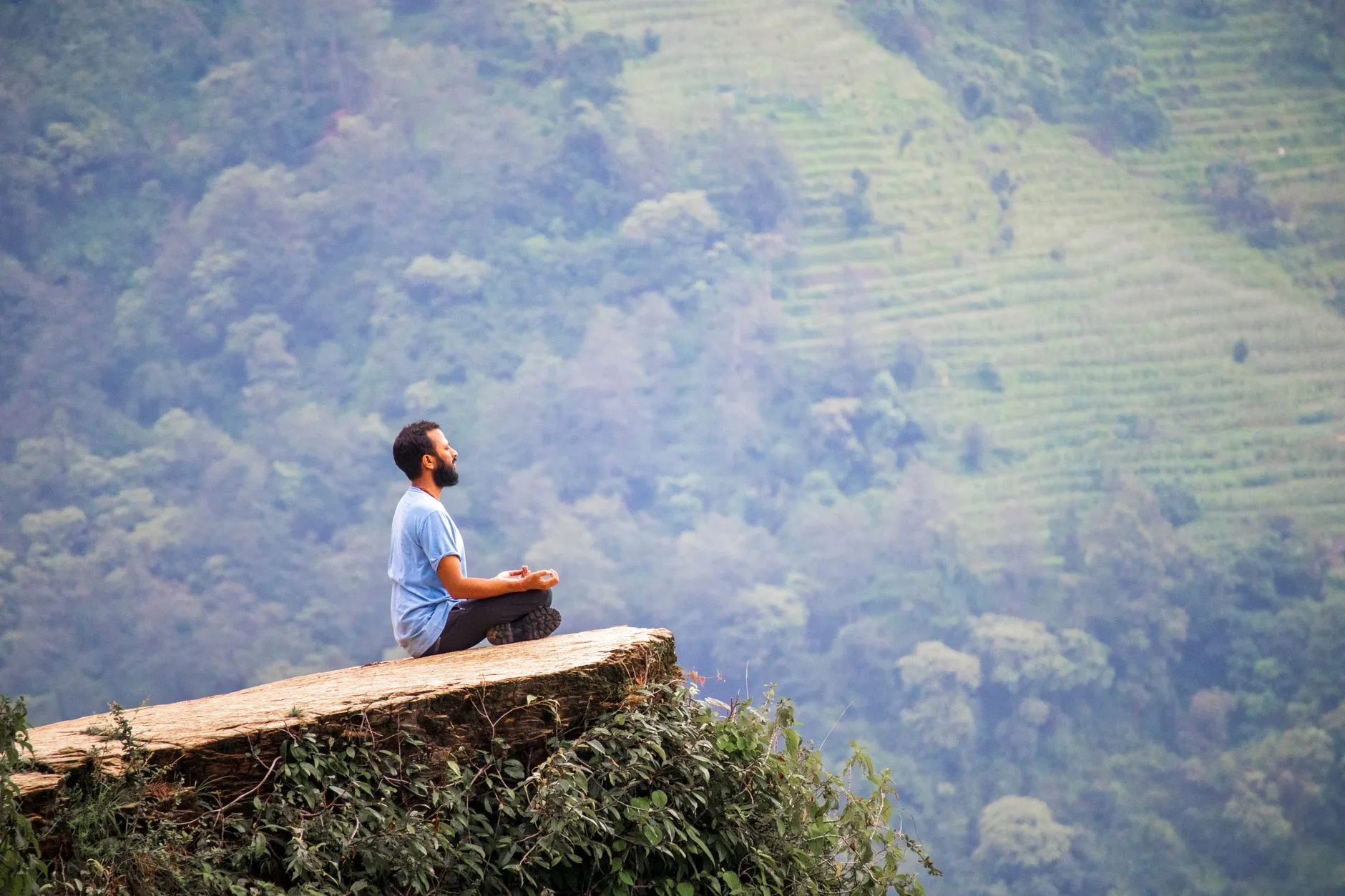 A yogi meditating amid lush greenery during a retreat.