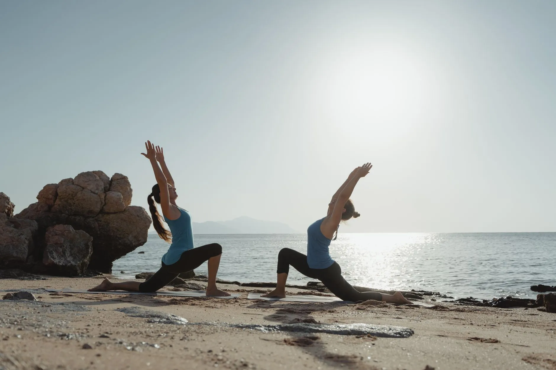 Yoga class conducted on a beach during sunset.
